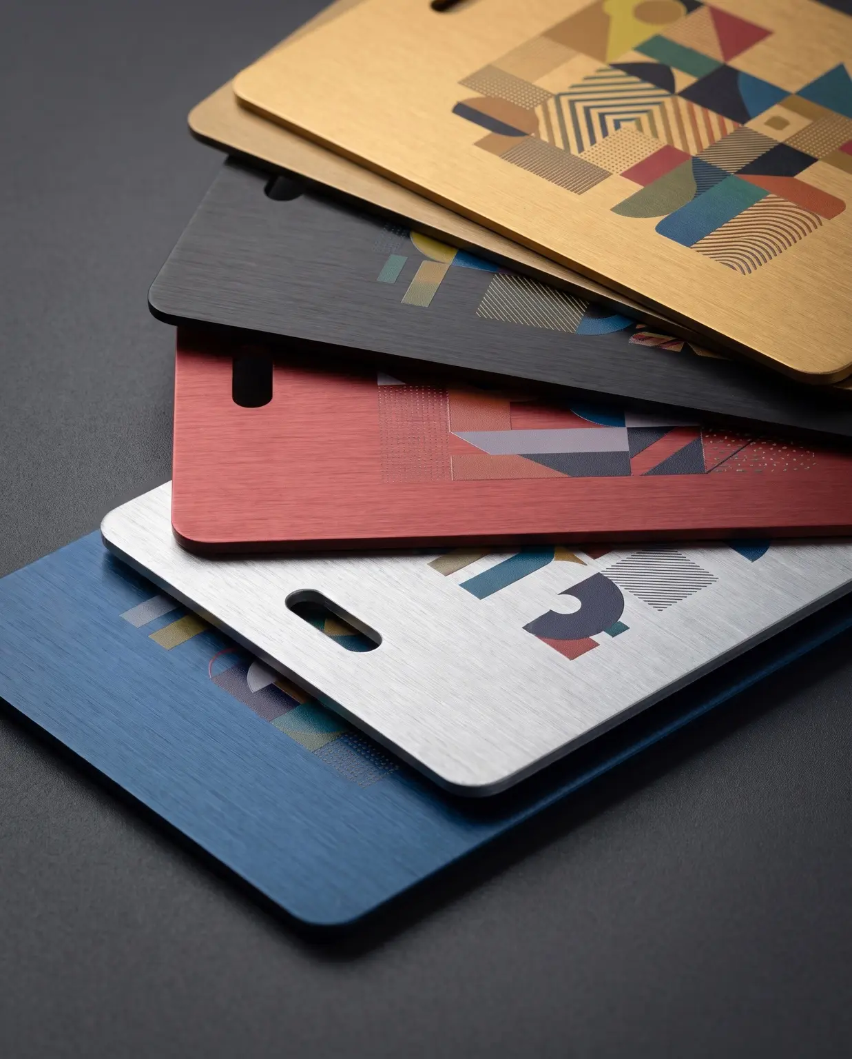 A group of thin printed and anodised cards showing colour and graphic finishing possibilities